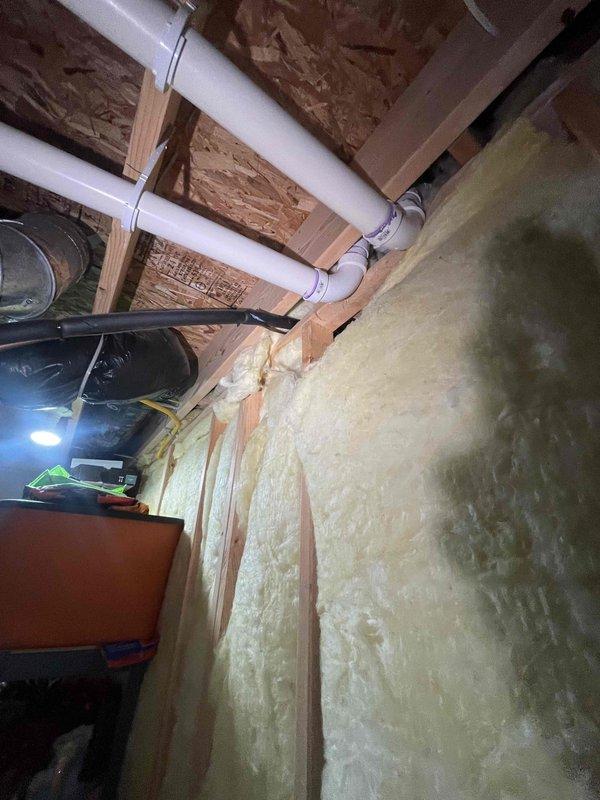 Conducted on-site assessment for replacement estimate of 13-year-old forced air furnace and air conditioning system. Evaluated existing HVAC equipment located in utility space, documented current installation configuration including ductwork routing, venting arrangements, and electrical connections. Photographed mechanical room layout showing water heater proximity, available clearances for new equipment installation, and existing PVC condensate drain lines. Assessed attic/basement space constraints, noting spray foam insulation application and structural framing that will impact equipment placement and duct modifications. Provided comprehensive replacement quote for new heating and cooling system to address aging equipment concerns.