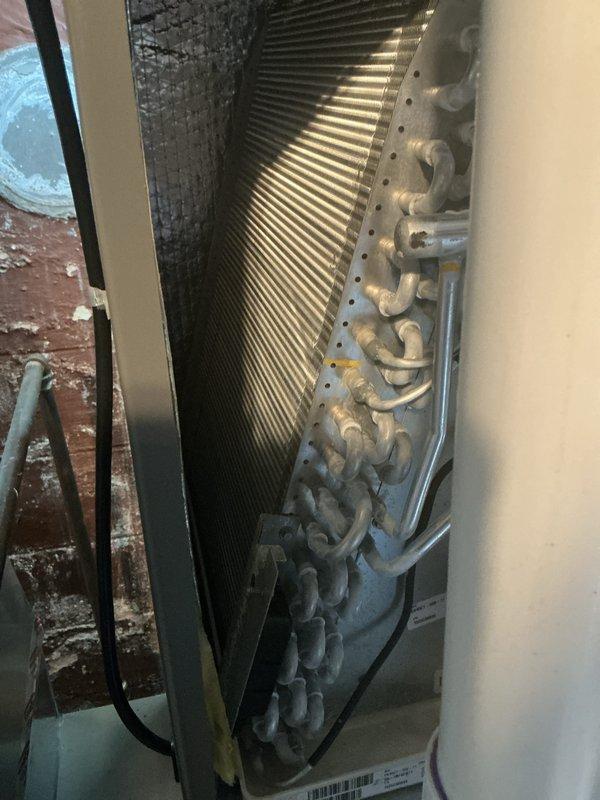 Completed annual cooling maintenance on HVAC system. Performed comprehensive inspection of evaporator coil, refrigerant lines, and associated components. Documented system condition with photographic evidence showing clean coil fins, properly secured copper refrigerant tubing, and accumulator assembly. All components operating within normal parameters with no deficiencies noted.