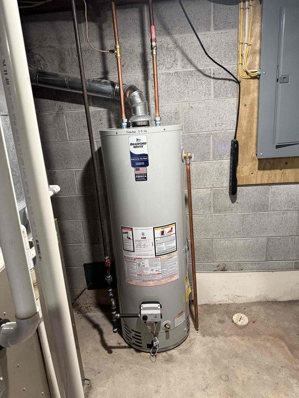 Successfully installed a 40-gallon Bradford White natural draft water heater, model RG240S6N, in basement utility room. Completed all copper piping connections to the unit, including hot and cold water lines with appropriate shut-off valves and pressure relief valve installation. Connected natural draft flue venting system to existing vent stack for proper exhaust of combustion gases. Secured unit with proper mounting brackets on concrete floor and verified all plumbing connections for leak-free operation. Installation included electrical wiring connections and compliance with manufacturer specifications for professional installation requirements.