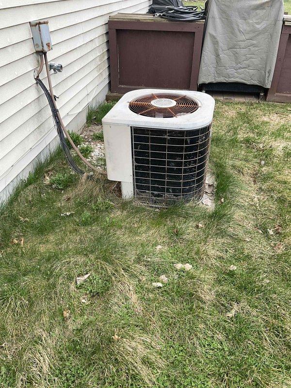 Provided comprehensive replacement estimate for 20-year-old residential HVAC system including outdoor air conditioning condenser unit located on concrete pad in backyard and basement furnace equipment utilizing natural gas fuel. Assessed existing equipment condition, photographed current installation showing weathered outdoor condenser with protective grilles and electrical disconnect, documented electrical panel location in decorated utility space, and reviewed system specifications to develop complete replacement proposal for aging equipment no longer operating efficiently.