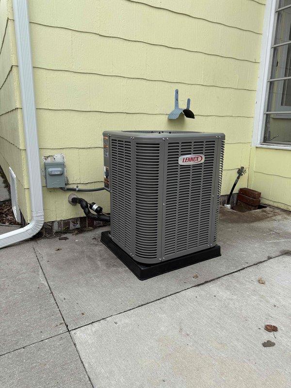 Completed full installation of 2-ton Lennox air conditioning system with matching evaporator coil at residential property. Installed outdoor condensing unit on concrete pad with proper refrigerant line connections and electrical hookup, positioned at rear of structure with adequate clearance for airflow and service access. Mounted new evaporator coil to existing furnace system in basement utility area, connected refrigerant lines through exterior wall penetration, and completed all necessary ductwork connections. Obtained required mechanical and air conditioning permits prior to installation. Verified proper refrigerant charge, tested system operation for cooling performance, and confirmed all electrical connections meet code requirements.