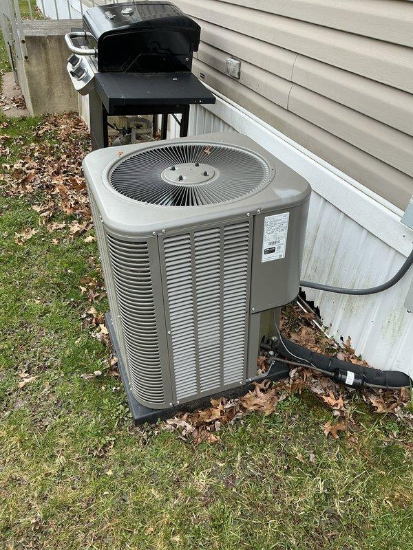 Completed annual air conditioning tune-up and maintenance on residential outdoor condenser unit. Performed comprehensive system inspection including checking refrigerant levels, testing electrical connections at disconnect box, cleaning condenser coils, verifying proper airflow through louvered panels, and confirming fan operation. Unit operating within normal parameters with no issues identified. Documented equipment condition with photos showing condenser positioned on pad with appropriate clearances from structure.