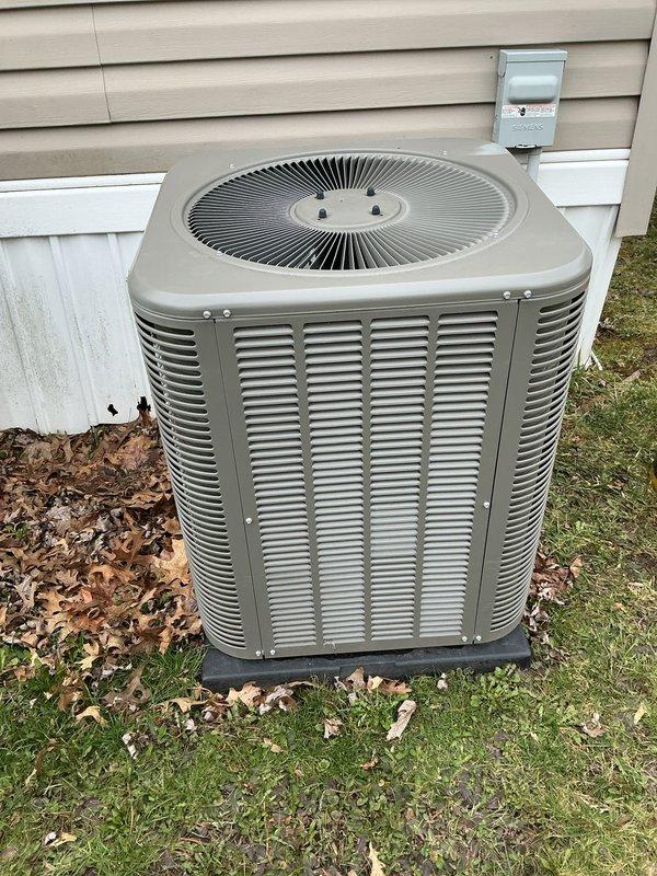 Completed annual air conditioning tune-up and maintenance on residential outdoor condenser unit. Performed comprehensive system inspection including checking refrigerant levels, testing electrical connections at disconnect box, cleaning condenser coils, verifying proper airflow through louvered panels, and confirming fan operation. Unit operating within normal parameters with no issues identified. Documented equipment condition with photos showing condenser positioned on pad with appropriate clearances from structure.