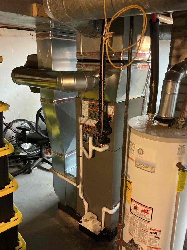 Completed full HVAC system installation in basement utility room, including new Lennox furnace unit (45,000 BTU capacity) mounted on platform with humidifier and liner. Installed 1.5 ton air conditioning system with rear discharge configuration. Ran new PVC vent piping vertically from furnace top for proper ventilation and drainage. Connected galvanized metal supply ductwork and installed necessary return air components. Established new dedicated electrical circuit to code for system operation. Mechanical and electrical permits obtained prior to installation. All equipment properly positioned, secured, and connected to existing infrastructure. System tested and verified operational upon completion.