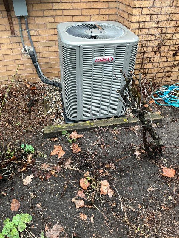 Completed annual air conditioning maintenance on Lennox condenser unit per membership agreement. Performed comprehensive AC tune-up including system inspection, cleaning of outdoor unit and surrounding area which had accumulated seasonal debris and leaves, checked refrigerant levels and lines, tested electrical components, verified proper airflow through louvers and fan operation, and confirmed system operating within manufacturer specifications. Unit showed no issues; all components functioning properly. Photos documented equipment condition and installation.