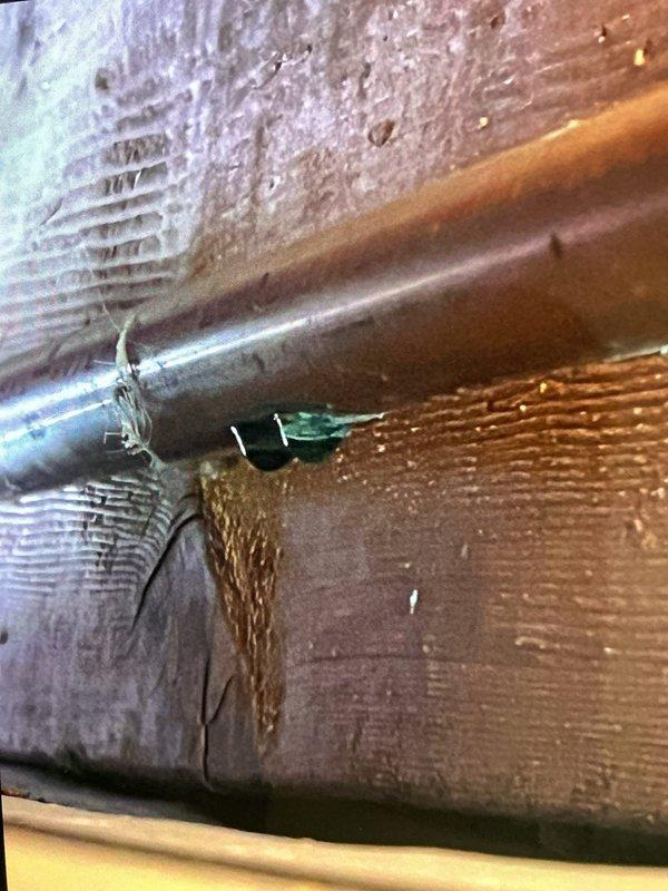 Responded to report of water leaking from ductwork connected to 3-year-old furnace system in basement. Upon inspection, identified moisture infiltration at duct junction near copper plumbing line, with visible water staining on adjacent wooden structural members. Documented conditions showing discoloration patterns on floor joists indicating ongoing moisture exposure. Examined main supply plenum and ductwork connections for condensation issues or external water sources. Photographed affected areas including duct-to-plenum connections and proximity to plumbing penetrations for warranty documentation purposes.