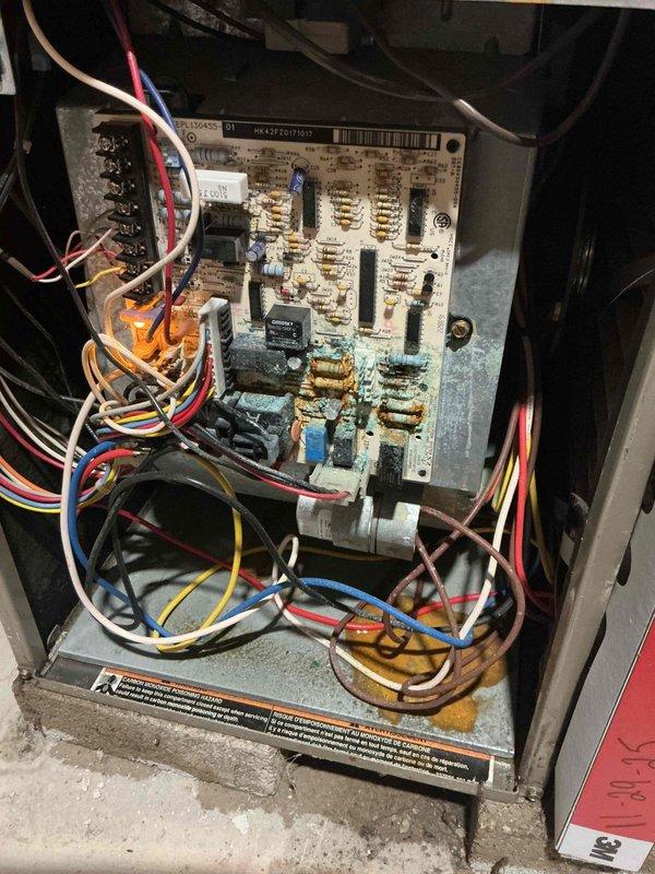 Responded to emergency service call for basement flooding and inoperative water heater with extinguished pilot light. Upon arrival, assessed flooded basement conditions and confirmed pilot light was out on tanked water heater. Conducted visual inspection of HVAC system control panel and furnace unit as requested. Discovered extensive corrosion on circuit board with white, blue-green, and turquoise crystalline deposits affecting electrical connections, relays, and terminal blocks throughout lower and middle sections of board. Documented corrosion damage affecting multiple components and connection points. Relit pilot light on water heater and verified proper ignition. Scheduled separate maintenance appointment for comprehensive furnace and air conditioning system evaluation due to severity of corrosion findings and need for additional service time.