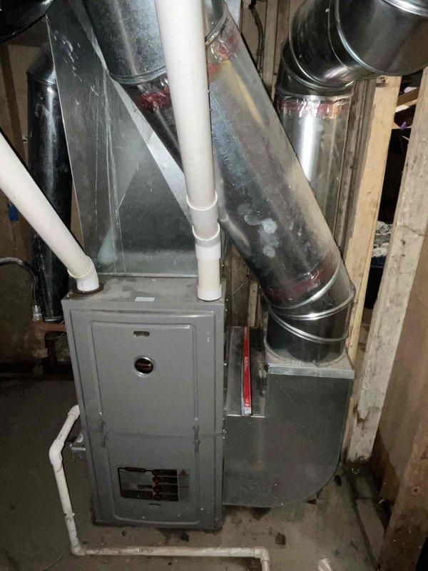 Conducted comprehensive assessment of basement HVAC system following flooding incident that rendered existing furnace inoperable. Evaluated gray metal furnace unit, associated ductwork, PVC venting system, and electrical panel to determine extent of water damage and replacement requirements. Documented current equipment configuration including metallic ductwork connections, condensate drainage lines, and electrical service panel condition showing signs of age and deterioration. Provided detailed replacement estimate for furnace and air conditioning system, including equipment specifications and installation scope for complete HVAC system upgrade.