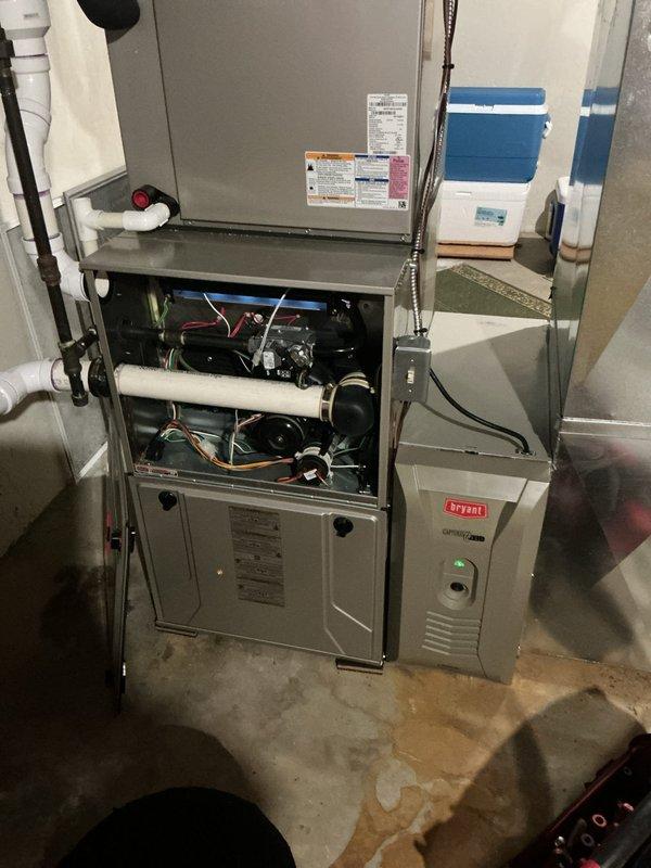 Responded to service call for non-operational humidifier with no water flow through unit. Upon arrival, inspected residential HVAC system including furnace and Bryant air handler assembly in basement mechanical room. Removed furnace access panel to examine internal components, wiring connections, and blower assembly. Verified humidifier installation, water supply line connections, and drainage system including PVC condensate piping. Inspected ductwork connections and air filtration system to ensure proper airflow through humidifier pad. Diagnosed issue preventing water distribution through humidifier media and restored unit to operational status.