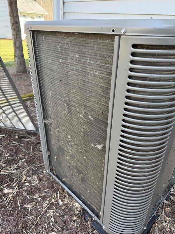 Performed scheduled air conditioning maintenance on outdoor condenser unit. Inspected unit and identified heavily soiled mesh filter panel with significant accumulation of dust, debris, and organic matter requiring replacement. Replaced dirty filter and evaporative cooling pad to restore proper airflow and system efficiency.