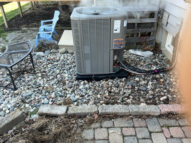 Completed full HVAC system installation including new gas furnace in basement mechanical room and outdoor condensing unit. Installed furnace with proper PVC venting routed upward, connected to existing ductwork system, and positioned unit adjacent to water heater. Installed outdoor condensing unit on pad with river rock base, ran refrigerant lines and electrical conduit to exterior wall penetration, and connected system components for complete heating and cooling operation.