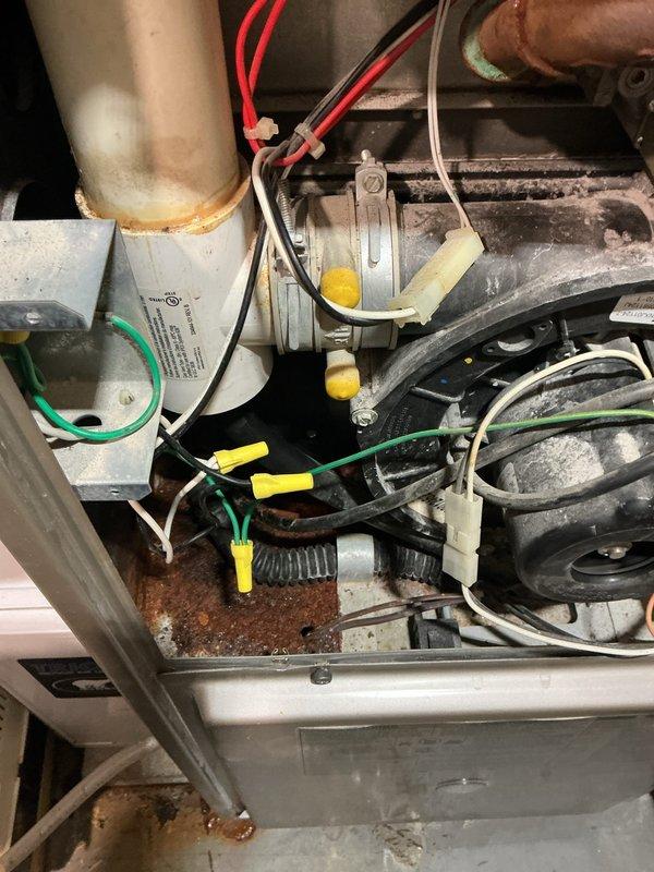 Responded to service call for furnace leaking water in basement location. Upon inspection, found extensive corrosion and rust on furnace cabinet and internal components, indicating prolonged moisture exposure. Identified water leakage issue originating from condensate drainage system. Inspected blower assembly, heat exchanger access area, and all visible ductwork connections for signs of active leaking and moisture accumulation. Documented heavily deteriorated condition of unit cabinet and internal metal surfaces with significant oxidation present. Verified electrical connections and wiring harnesses showed signs of age-related degradation with corrosion staining visible on lower cabinet panels. Advised customer of furnace condition and recommended replacement due to advanced age and extensive corrosion compromising unit integrity and safety.