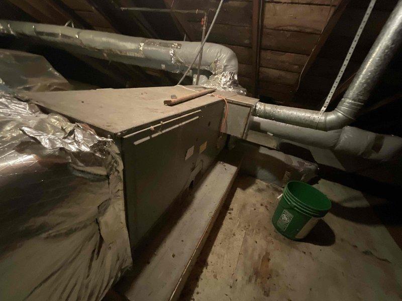 Conducted comprehensive assessment of residential attic space for first-time central air conditioning and new furnace installation in single-family home. Evaluated existing attic infrastructure, including wooden rafter system, floor joists, and available space for equipment placement. Documented current HVAC equipment configuration, including existing air handler unit with flexible aluminum ductwork distribution system and secondary furnace/air handler unit with mixed rigid and flexible duct connections. Assessed electrical service availability, condensate drainage requirements, and structural support adequacy for new equipment installation. Photographed attic access points, existing ductwork routing, mechanical equipment positioning, and available installation space. Identified need for full system replacement to add cooling capacity where none currently exists and upgrade heating equipment. Provided homeowner with detailed estimate for complete HVAC system installation including new 