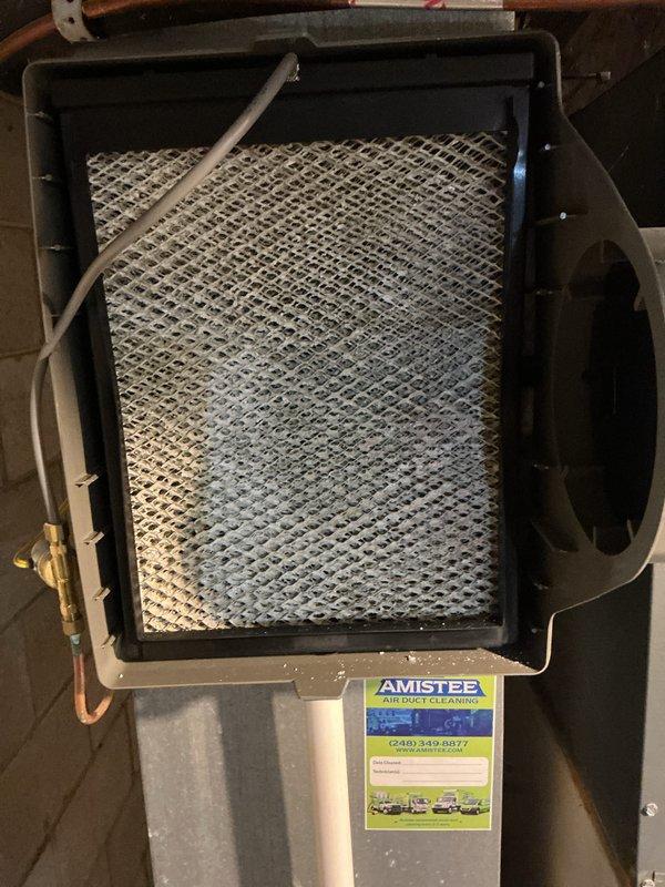 Performed routine air conditioning maintenance inspection on residential HVAC system. Upon inspection, identified dirty and clogged air filter with significant dust accumulation and discoloration affecting system airflow efficiency. Removed and replaced contaminated mesh filter with new unit to restore proper air circulation and system performance. Completed standard ACM protocol including visual inspection of furnace unit, ductwork connections, and associated components. System operational and running efficiently following filter replacement.