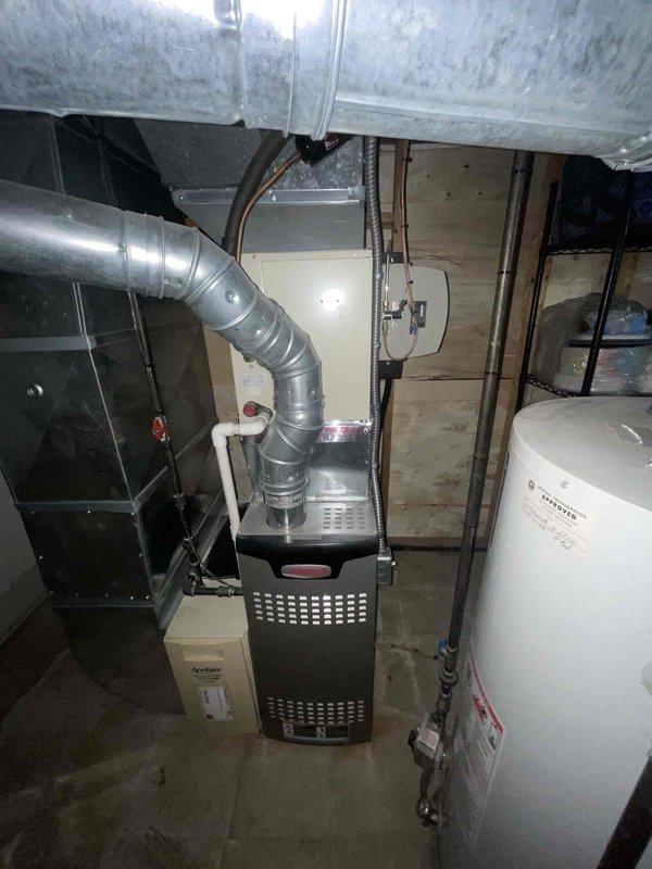Completed comprehensive assessment of existing air conditioning system for replacement estimate at residential property. Homeowner recently relocated and required evaluation of current HVAC equipment with unknown service history and age. Inspected basement mechanical room containing existing furnace installation from 2023, water heater, and associated ductwork systems. Documented current equipment configuration including metallic ductwork connections, electrical panel infrastructure, plumbing systems, and overall mechanical room layout. Evaluated existing system capacity, condition, and compatibility requirements for proposed air conditioning replacement. Provided detailed replacement options and recommendations based on current equipment assessment and homeowner needs.