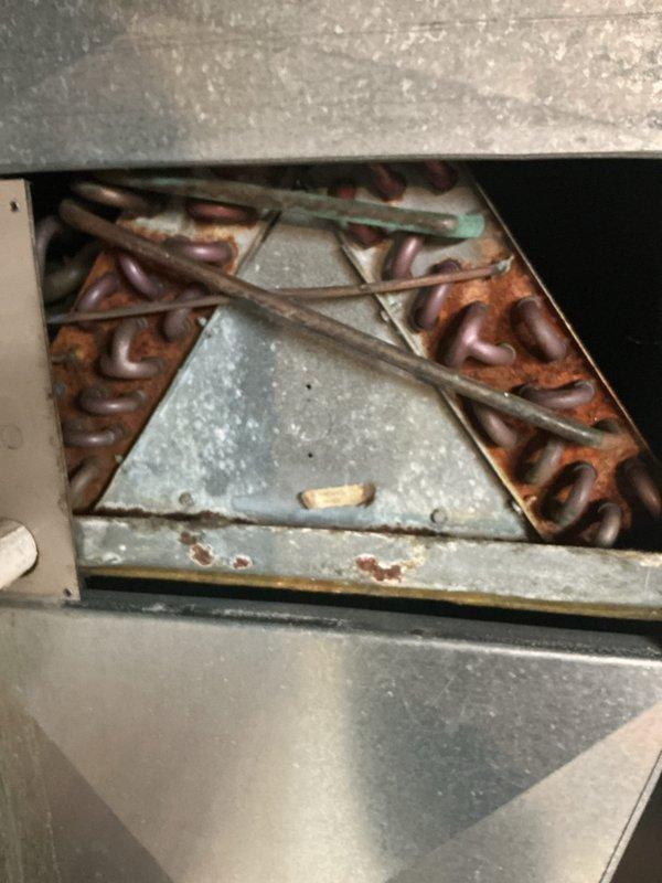 Completed annual HVAC maintenance inspection including filter replacement as scheduled. Upon inspection, discovered significant corrosion on evaporator coil assembly and internal components, including heavy rust on access panels and oxidation on copper refrigerant lines with visible green-blue patina. Documented equipment condition with UV diagnostic photography, which revealed deteriorated metal surfaces throughout the system requiring attention for continued reliable operation.