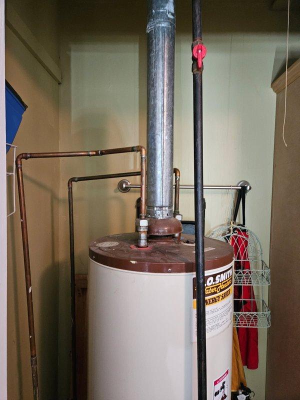 Completed ACM service call on water heater system at unit 4/910-2. Inspected water heater installation, verified proper venting configuration with metallic B-vent pipe extending through ceiling, and confirmed secure pipe connections and supports. Documented existing conditions including copper piping loop, gas line with shutoff valve, and ceiling penetration seal. All components photographed for service records per customer request.