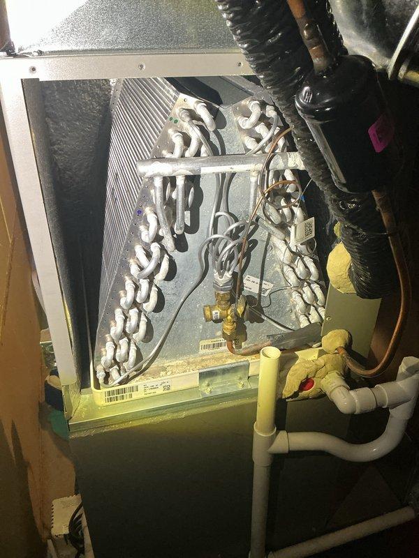 Completed routine Air Care Cooling maintenance on residential HVAC system. Performed comprehensive inspection of evaporator coil unit in attic space, verifying proper operation of serpentine copper tubing arrangement and checking condition of coil insulation. Inspected yellow condensate drain pan and white PVC drainage system for proper flow and potential blockages. Examined air handler unit with mesh filter, confirming adequate airflow and filter condition. Verified integrity of refrigerant lines, electrical connections, and flex ductwork connections throughout the system. All components found operating within normal parameters with no immediate service needs identified.