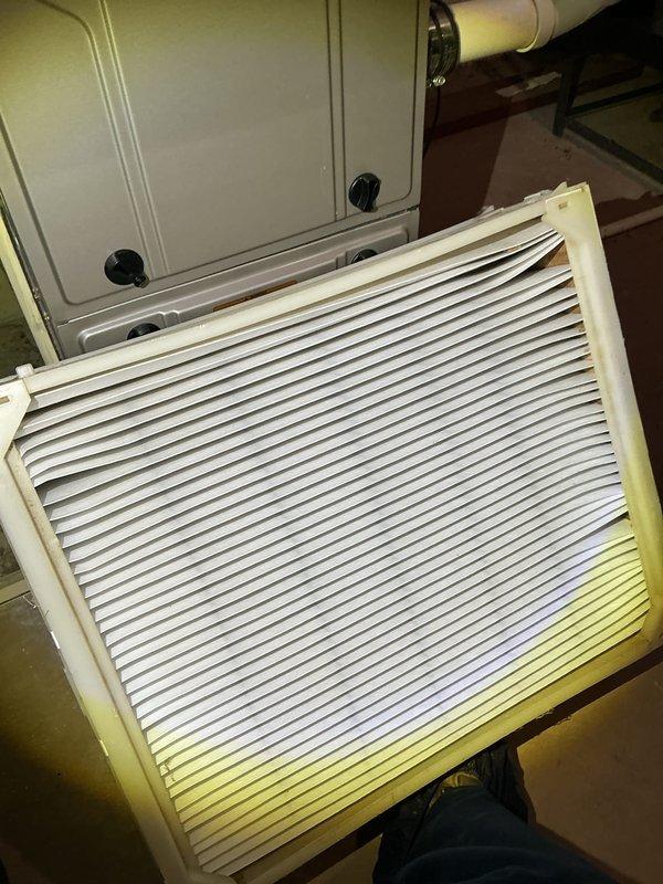 Performed comprehensive air conditioner tune-up maintenance under active service contract. Inspected and photographed return air filter showing dust accumulation along bottom edge; documented HVAC equipment including air handler unit and ductwork connections. Accessed interior components of system to inspect heat exchanger coils, capacitor, and associated electrical connections. All components found operating within normal parameters with no deficiencies requiring immediate attention. System confirmed functioning properly upon completion of routine maintenance procedures.
