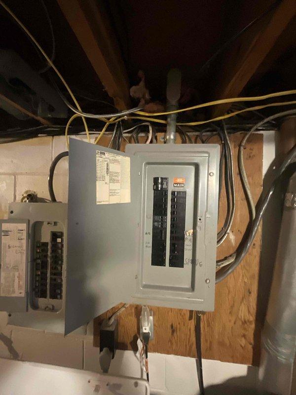 Conducted on-site evaluation for furnace replacement estimate on a 30-year-old heating system originally installed in 1996. Performed visual inspection of existing Lennox outdoor condensing unit positioned on concrete pad adjacent to home's foundation, noting refrigerant lines and electrical conduit routing up exterior wall. Assessed electrical service capacity by examining main breaker panel and circuit distribution in basement utility area to ensure adequate power supply for proposed equipment upgrade. Documented current HVAC infrastructure including ductwork accessibility and existing equipment configuration to provide accurate replacement recommendations and specifications for new high-efficiency furnace installation.