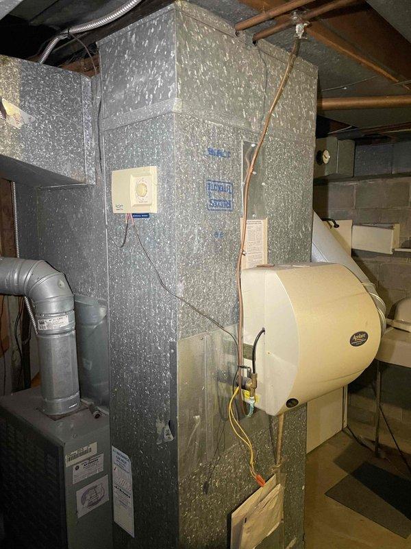 Provided comprehensive estimate for complete furnace replacement on 18-year-old existing unit, including assessment of current HVAC system configuration with humidifier integration and ductwork connections. Documented existing Amana model AUD080R936K0 furnace installation with attached whole-house humidifier and evaluated replacement options as part of promotional BOGO program that includes complimentary air conditioning system with new furnace purchase.