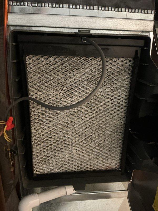 Completed annual Air Care Cooling maintenance inspection on residential HVAC system. Accessed furnace unit, inspected burner assembly and heat exchanger, verified proper operation of all components, and replaced dirty air filter with new unit. Documented equipment condition with photographs showing filter housing assembly and furnace interior components including burner, gas piping, electrical connections, and vent system.