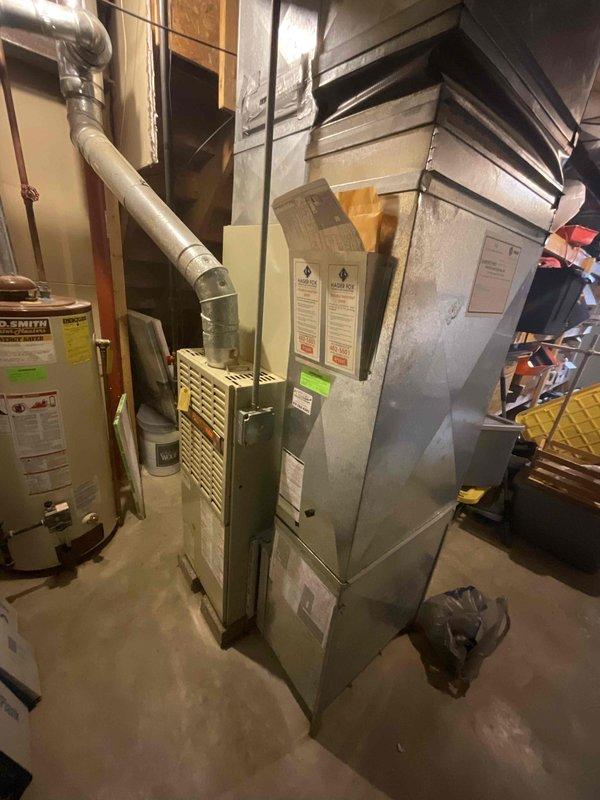 Conducted comprehensive estimate for complete HVAC system replacement in residential basement mechanical room. Existing furnace and air conditioning equipment evaluated at approximately 28 years of age, well beyond typical service life expectancy. Documented current system configuration including forced-air furnace with white air handler assembly, ductwork connections, and associated AC evaporator coil. Assessed electrical service panel capacity and existing wiring infrastructure to ensure compatibility with new equipment installation. Photographed mechanical room layout, equipment positioning, available clearances, and accessibility for replacement work. Evaluated ductwork connections, condensate drainage requirements, and ventilation exhaust routing. Reviewed electrical panel for adequate breaker capacity and proper circuit availability for new system. Provided recommendations for expedited replacement scheduling based on equipment age and homeowner urgency.