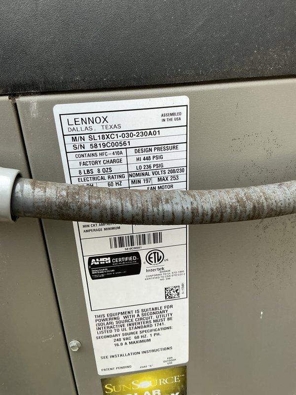 Completed annual maintenance on Lennox SL18XC1-030 outdoor condensing unit containing HFC-410A refrigerant. Inspected manufacturer specifications and confirmed proper labeling. Observed significant debris accumulation and discoloration on condenser coils, particularly on intake side, with visible buildup of leaves, pollen, and environmental contaminants between fins. Documented equipment condition through photographs showing operational unit with weathering consistent with outdoor exposure.
