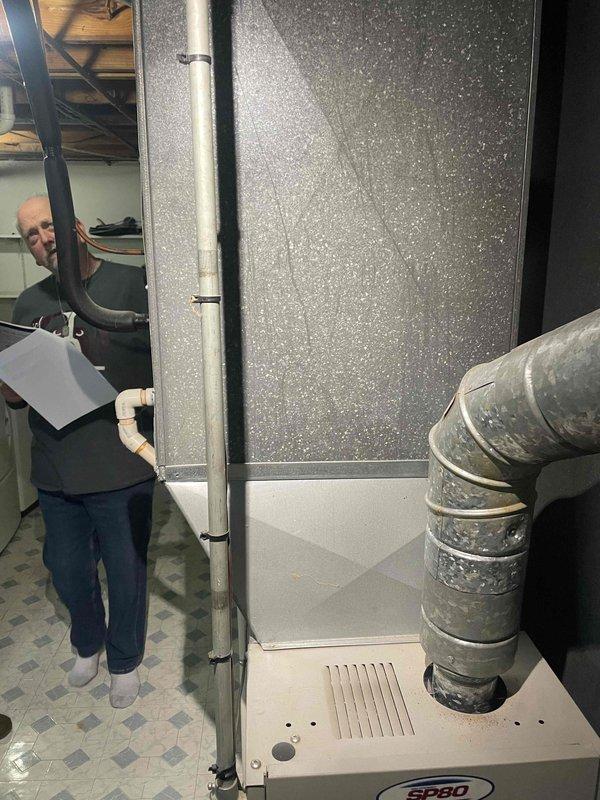 Conducted estimate consultation for replacement of 26-year-old furnace unit located in basement utility room. Assessed existing gray metal furnace with associated ductwork, PVC condensate drain line, and flexible duct connections to provide equipment replacement options and pricing for homeowner consideration.