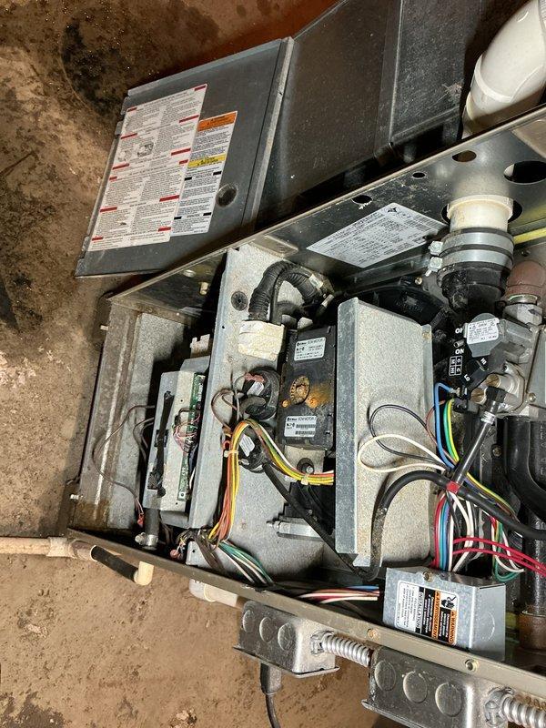 Responded to service call for 13-year-old furnace located in basement. Performed diagnostic inspection of unit, accessing internal components including blower motor assembly, control boards, gas valve connections, and electrical wiring systems. Conducted visual examination of all mechanical components, verified proper connections, and assessed overall system condition. Documented equipment configuration and current operational status with detailed photographs of furnace cabinet, internal components, PVC venting, and surrounding mechanical systems.