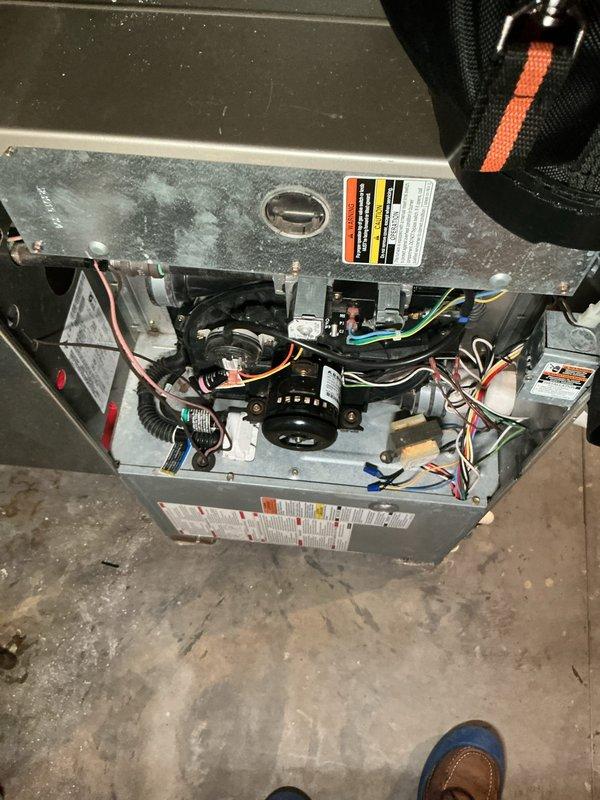 Completed annual cooling maintenance on HVAC system. Performed comprehensive inspection of furnace unit with access panel removed to evaluate internal components including blower motor assembly, electrical connections, and control board. Verified proper electrical readings using digital multimeter, measuring 67.9 on system diagnostics. Inspected all wire connections including orange, blue, green, white, and red conductor pathways for secure terminations and signs of wear. Evaluated control board functionality and verified all safety labels present and legible. System operational and ready for cooling season.