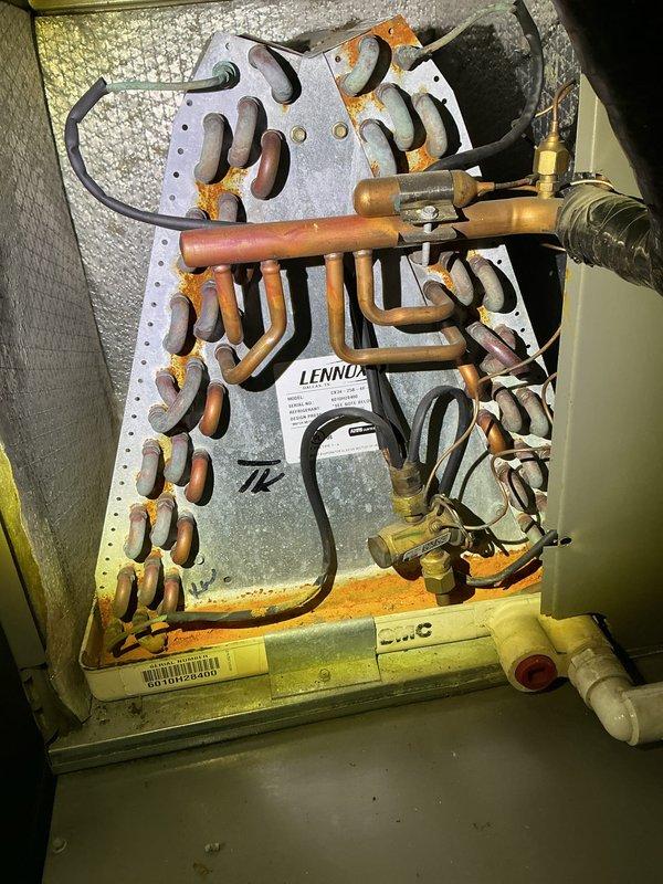 # HVAC Maintenance - ACM Completed

Performed comprehensive annual cooling maintenance on Lennox HVAC system. Conducted thorough inspection of evaporator coil assembly and refrigerant lines using UV light for enhanced visibility. Assessed heat exchanger coil condition, noting significant oxidation and surface corrosion on copper tubing throughout the serpentine coil arrangement. Inspected all refrigerant line connections, brass fittings, and copper piping for integrity. Verified condensate drain system components including PVC drain line with proper cap installation. Examined electrical connections and insulated refrigerant lines. Documented equipment condition with photographic evidence showing extensive copper patina development on coil surfaces, indicating age-related weathering. All accessible components inspected per manufacturer maintenance protocols. System operational at time of service completion.