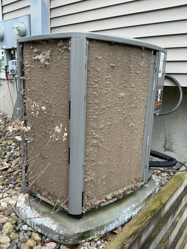 Performed complete air conditioning tune-up and cleaning on outdoor condensing unit. Unit exhibited heavy accumulation of dirt, dust, and debris on coil surfaces and intake panels, which was thoroughly cleaned to restore proper airflow and system efficiency. Removed vegetation and organic debris from around unit base and verified all components operating within normal parameters.