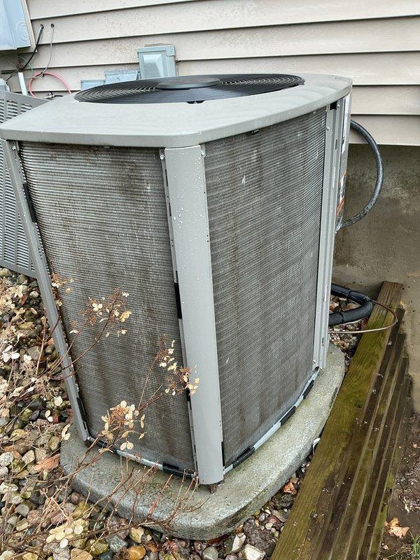 Performed complete air conditioning tune-up and cleaning on outdoor condensing unit. Unit exhibited heavy accumulation of dirt, dust, and debris on coil surfaces and intake panels, which was thoroughly cleaned to restore proper airflow and system efficiency. Removed vegetation and organic debris from around unit base and verified all components operating within normal parameters.