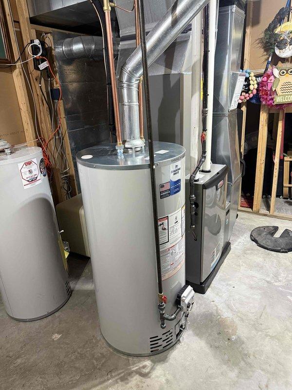 Installed a new 50-gallon Bradford White tanked water heater in residential basement utility room. Connected copper supply piping with brass fittings and yellow-handled shut-off valves, installed galvanized metal vent pipe with proper securing bands, and completed all electrical reconnections. Mechanical permit obtained and all work performed to code specifications.