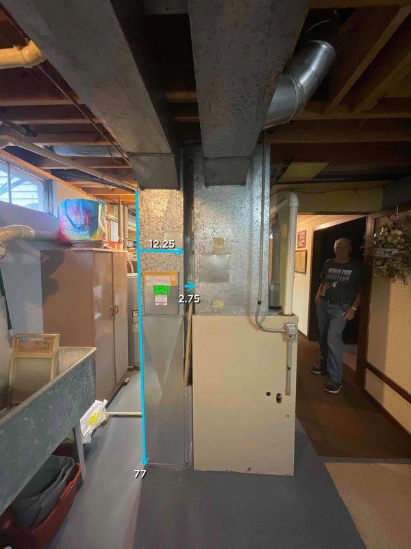 Conducted on-site assessment of 26-year-old residential furnace system located in basement area for replacement estimate. Documented existing equipment configuration, including current HVAC unit positioning relative to structural support column, clearance measurements, and existing ductwork connections. Captured detailed measurements and photographic documentation of installation space, noting copper piping routes, metallic ductwork elbows, and available clearances for new equipment installation. Evaluated basement access points, ceiling height with exposed joists, and concrete floor conditions to determine optimal replacement unit specifications and installation requirements for future summer 2026 replacement appointment.