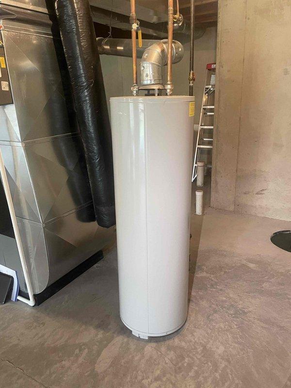 Conducted plumbing estimate for standard natural draft water heater replacement in residential property. Evaluated existing aged water heater installation in basement utility room alongside previously installed HVAC system. Customer requested estimate for standard tank-style water heater replacement to replace aging unit that is still operational but nearing end of service life.