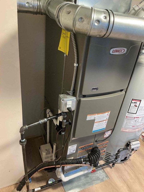 Successfully completed full HVAC system installation including a Lennox 45,000 BTU furnace with humidifier and flue liner, 1.5 ton air conditioning condenser unit, and hot water heater replacement. All equipment was properly positioned, with the furnace installed in the mechanical room featuring complete ductwork connections and condensate drainage system, while the outdoor AC unit was mounted on a rubber isolation pad with refrigerant lines, electrical disconnect box, and conduit properly secured to exterior wall. System was tested, reconnected to existing infrastructure, and confirmed operational upon completion.