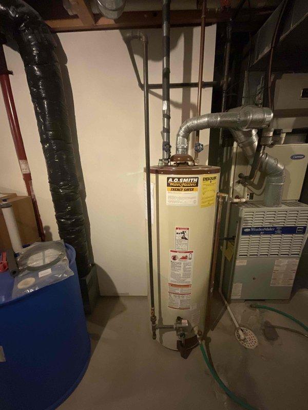 Provided estimate for water heater replacement in basement utility area. Assessed existing A.O. Smith water heater installation alongside blue pressure tank and Carrier HVAC system. Customer requested quote for standard water heater replacement, with venting configuration requiring determination between power vent or natural draft application based on current setup evaluation.
