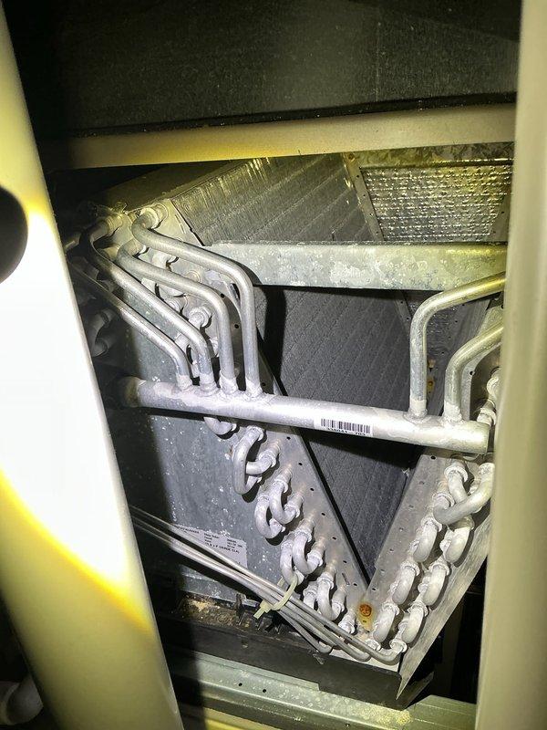 Completed comprehensive air conditioning maintenance inspection on residential HVAC system. Accessed air handler unit and thoroughly examined evaporator coil, which showed normal condensation accumulation indicating proper cooling operation. Inspected refrigerant line connections, heat exchanger coils, and serpentine tubing configuration—all components found to be in serviceable condition with typical dust accumulation for normal operation. Verified ductwork connections and insulation integrity throughout accessible areas. System operating within normal parameters at time of inspection.