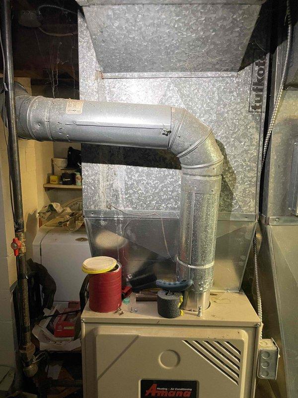 Conducted comprehensive evaluation of existing Amana furnace system and ductwork installation in basement utility area. Previous technician had identified discontinued components requiring replacement, prompting full system assessment. Performed detailed measurements of current ductwork dimensions and documented existing HVAC infrastructure including metallic supply ducts, flexible connections, and air distribution configuration. Evaluated furnace condition, examined ductwork routing with elbow joints and horizontal runs, and assessed overall system layout for replacement planning. Provided complete estimate for new full system installation to address obsolete components and ensure proper heating functionality for upcoming season.