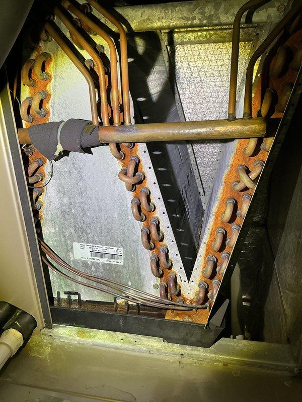Completed annual HVAC maintenance on air handler system. Performed comprehensive inspection of unit including heat exchanger coils, refrigerant lines, and condensate management components. Noted moderate oxidation on copper refrigerant piping and significant rust/corrosion on unit frame and mounting hardware, typical of age and environmental exposure. Inspected evaporator coil assembly and verified all mechanical connections secure. Checked condensate drain system for proper operation. Documented equipment condition with photos showing foil-backed insulation intact and unit operational. System running within normal parameters at time of service. Scheduled follow-up appointment for filter and pad replacement.