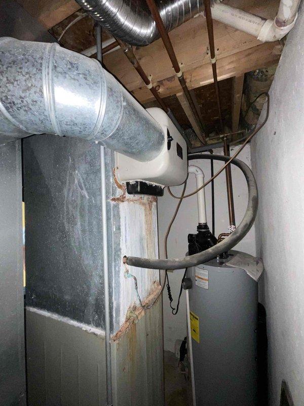 Conducted on-site assessment for complete HVAC system replacement at a residential property built circa 1992. Evaluated existing 34-year-old furnace and air conditioning system, both showing significant age-related deterioration including extensive rust staining on furnace cabinet, corroded pipe connections, and overall system wear. Documented equipment conditions, ductwork configuration in basement mechanical room, and existing infrastructure to provide comprehensive replacement quote for new furnace and AC installation.