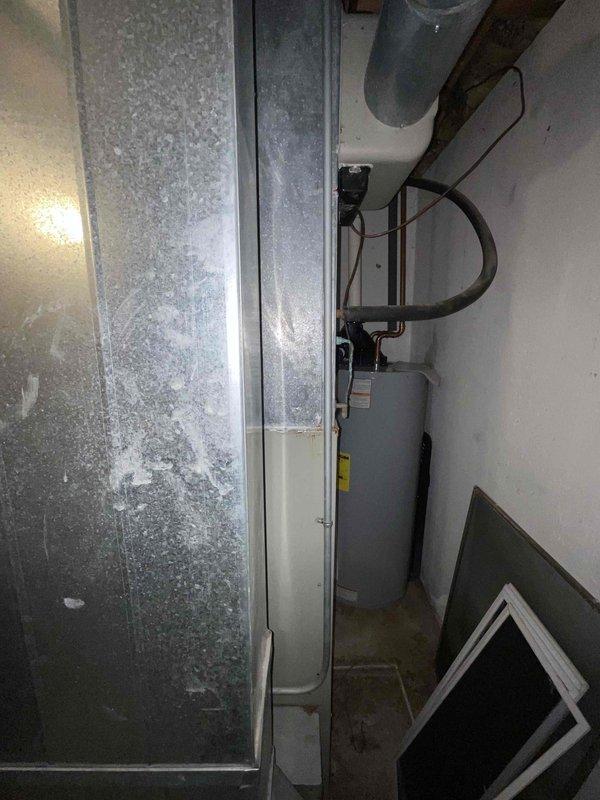 Conducted on-site assessment for complete HVAC system replacement at a residential property built circa 1992. Evaluated existing 34-year-old furnace and air conditioning system, both showing significant age-related deterioration including extensive rust staining on furnace cabinet, corroded pipe connections, and overall system wear. Documented equipment conditions, ductwork configuration in basement mechanical room, and existing infrastructure to provide comprehensive replacement quote for new furnace and AC installation.