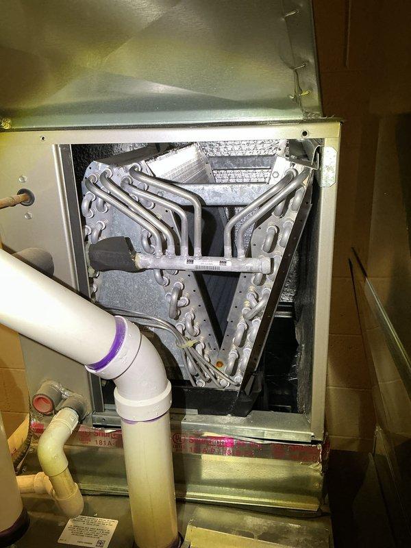 Completed annual cooling maintenance on residential HVAC system with dual Lennox furnace configuration and A-frame evaporator coil assembly. Inspected equipment operation, verified proper airflow through coil fins, checked condensate drain system with PVC piping, and documented system condition with photographs. All components found operating within normal parameters; no repairs required at this time.