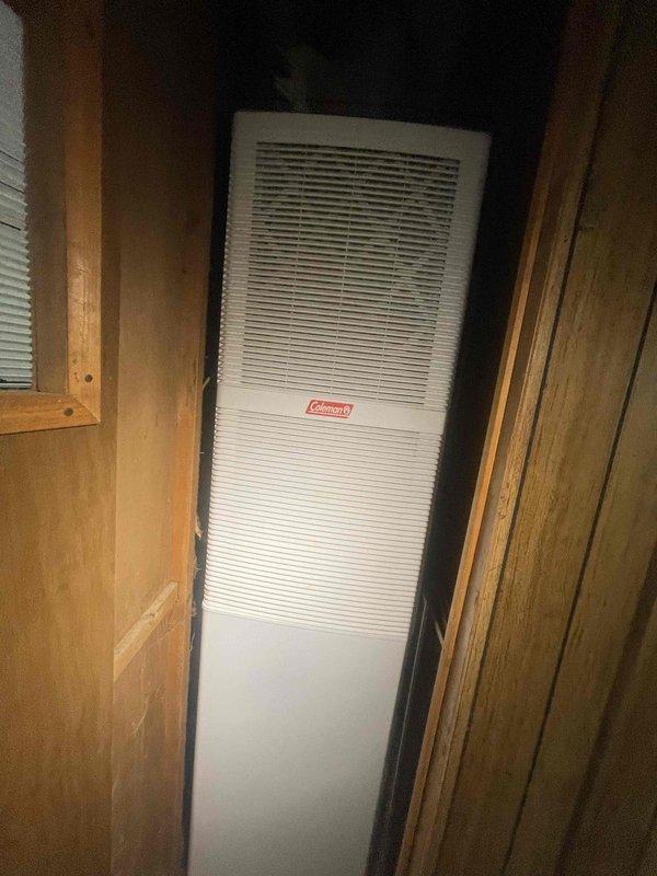 Provided estimate for new air conditioning system installation in a mobile home or RV application. Assessed the installation location, which features a narrow interior space with wooden panel framing designed to accommodate a Coleman heating and cooling unit. Evaluated the confined vertical space and existing infrastructure to determine proper equipment sizing and installation requirements for the new HVAC system.