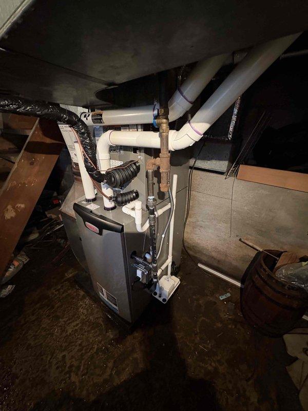 Completed full HVAC system installation including 70,000 BTU furnace, 2-ton air conditioning unit, and hot water heater replacement. Installed new furnace in basement with proper PVC venting configuration, black flexible ductwork connections, and all required piping with insulated joints. Positioned outdoor condenser unit on concrete pad with electrical disconnect box, conduit runs, and proper clearances from structure. All equipment installed per manufacturer specifications and local mechanical permit requirements, system tested and operational.