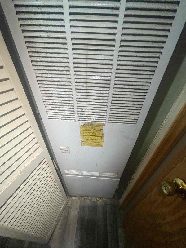 Conducted comprehensive site evaluation for full HVAC system replacement estimate at residential property with 16-year-old air conditioning system that experienced compressor failure several years ago. Assessed existing return air grille locations in stairwell area and utility closet, documented current ventilation configuration including louvered access panels and ductwork placement, and photographed installation areas to determine equipment specifications and replacement requirements for new central air conditioning unit.