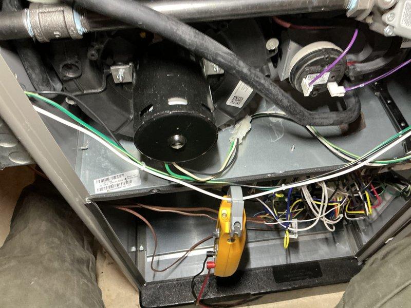 Completed annual heating and cooling maintenance inspection on HVAC system. Removed access panels to inspect blower motor assembly, capacitor, and electrical connections. Verified all wiring connections were secure, checked capacitor operation, and inspected blower motor for proper function. Documented equipment condition with photographs showing internal components including motor assembly, ductwork connections, and control wiring. All components found operating within normal parameters with no immediate service needs identified.