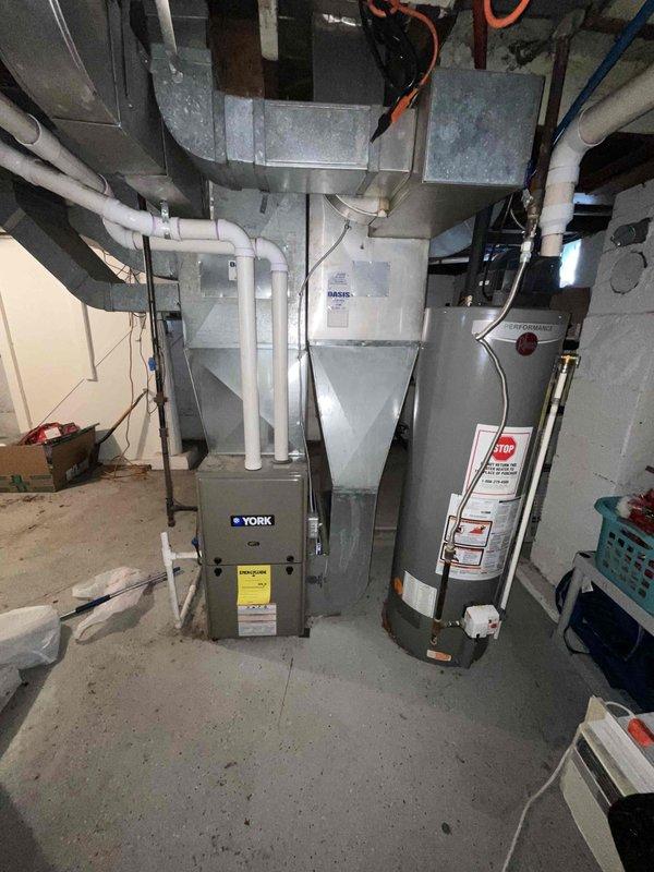 Conducted on-site evaluation of 20+ year old HVAC system in basement that was not cooling properly. Assessed existing York furnace and air conditioning equipment, documented current installation including ductwork configuration, condensate drainage system, and electrical connections. Provided comprehensive replacement estimate for complete system upgrade to address inadequate cooling performance and aging equipment.